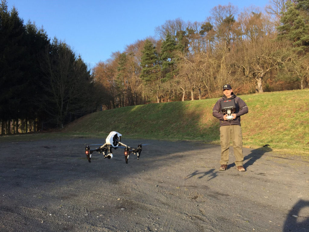 Ralf fliegt die Inspire-Drohne auf Augenhöhe über einem Schotterplatz.